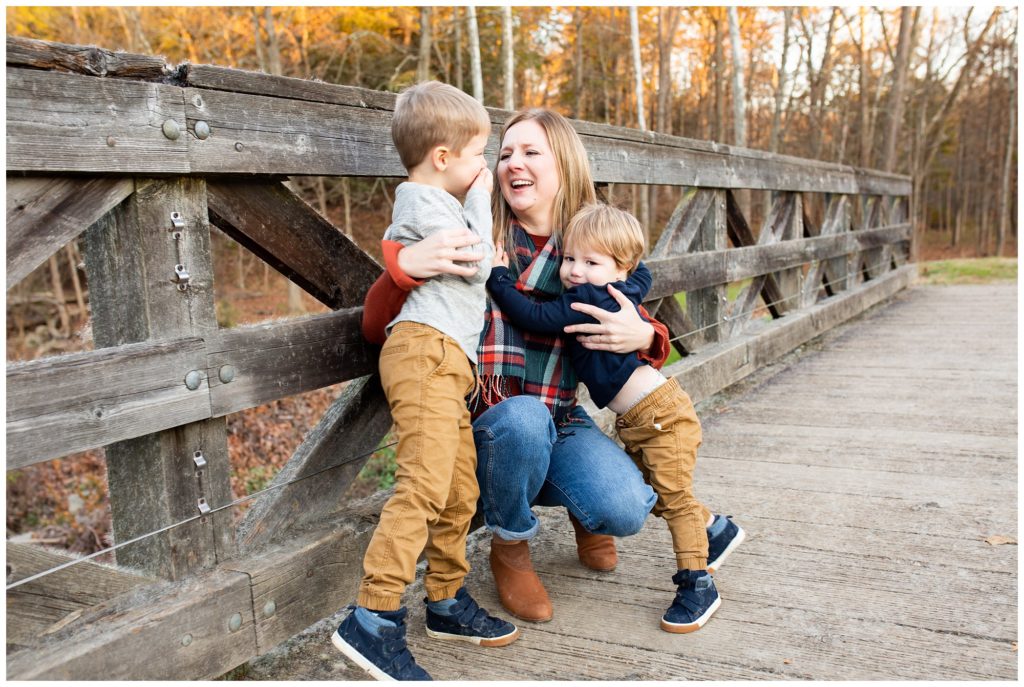Mom and sons hugging on bridge in emmerling park in fox chapel, pa