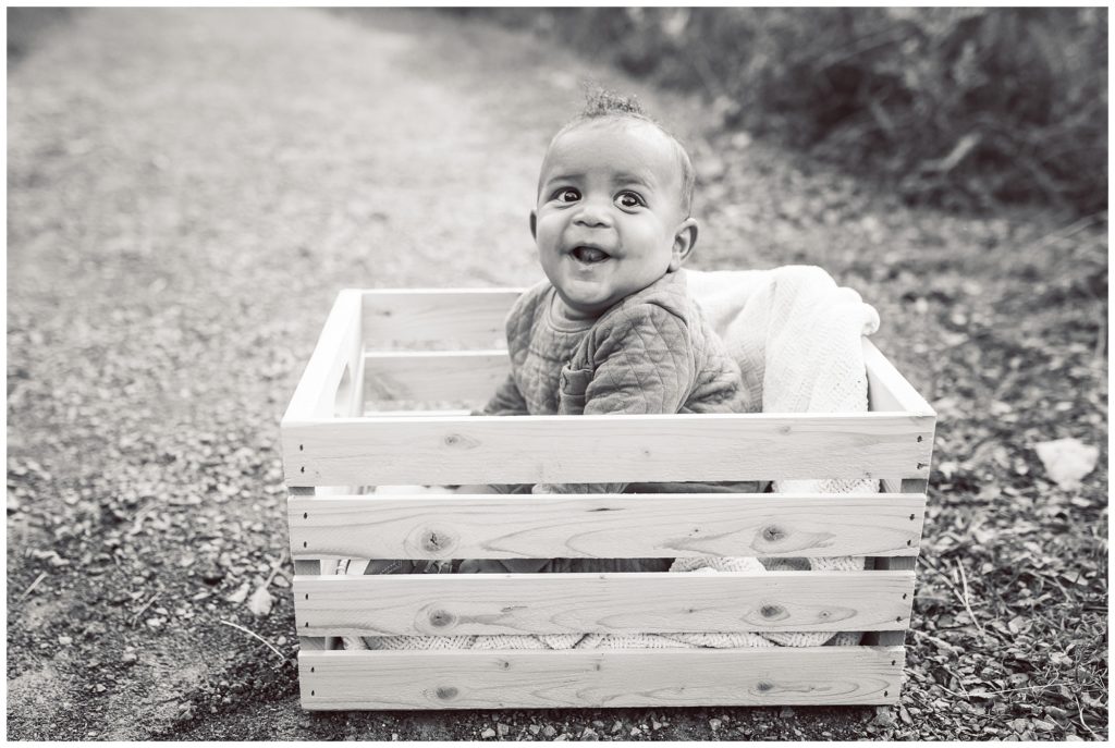 Baby smiling sitting in a apple crate