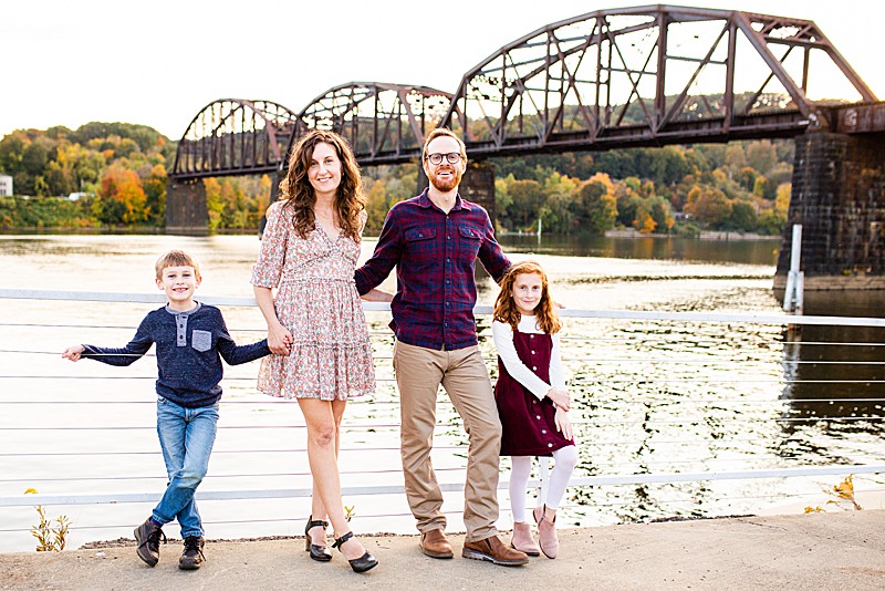 Family standing on Aspinwall Riverfront dock with Pittsburgh bridge behind them