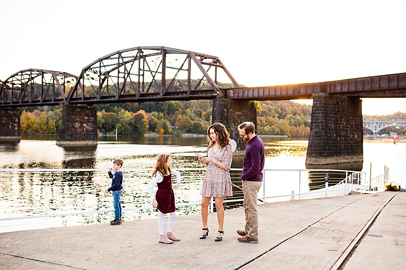 Family standing on the dock at Aspinwall Riverfront Park with bridge in the background
